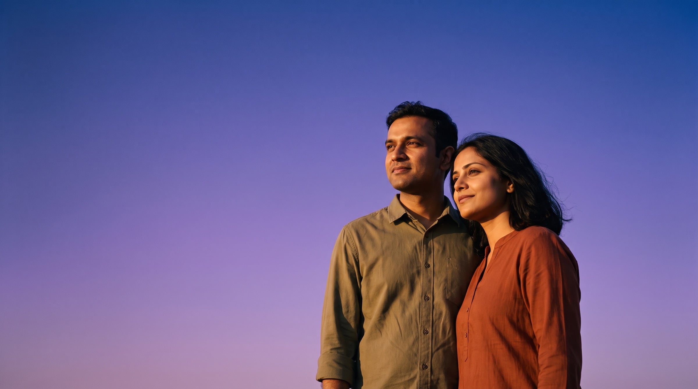 A couple in their thirties look toward the evening light.